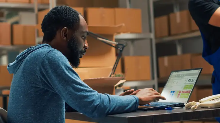 Responsable d'entrepôt qui suit les commandes sur un ordinateur portable