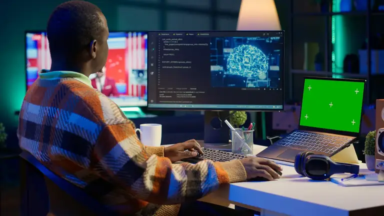 Développeur au travail sur plusieurs écrans, code et intelligence artificielle